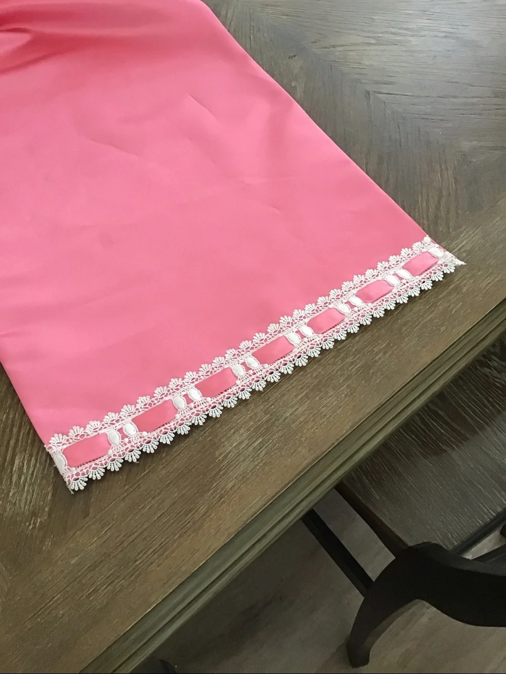 Table runner features a decorative white lace and ribbon trim